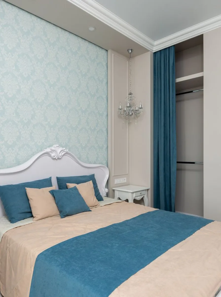 White and blue bedroom with teal curtains