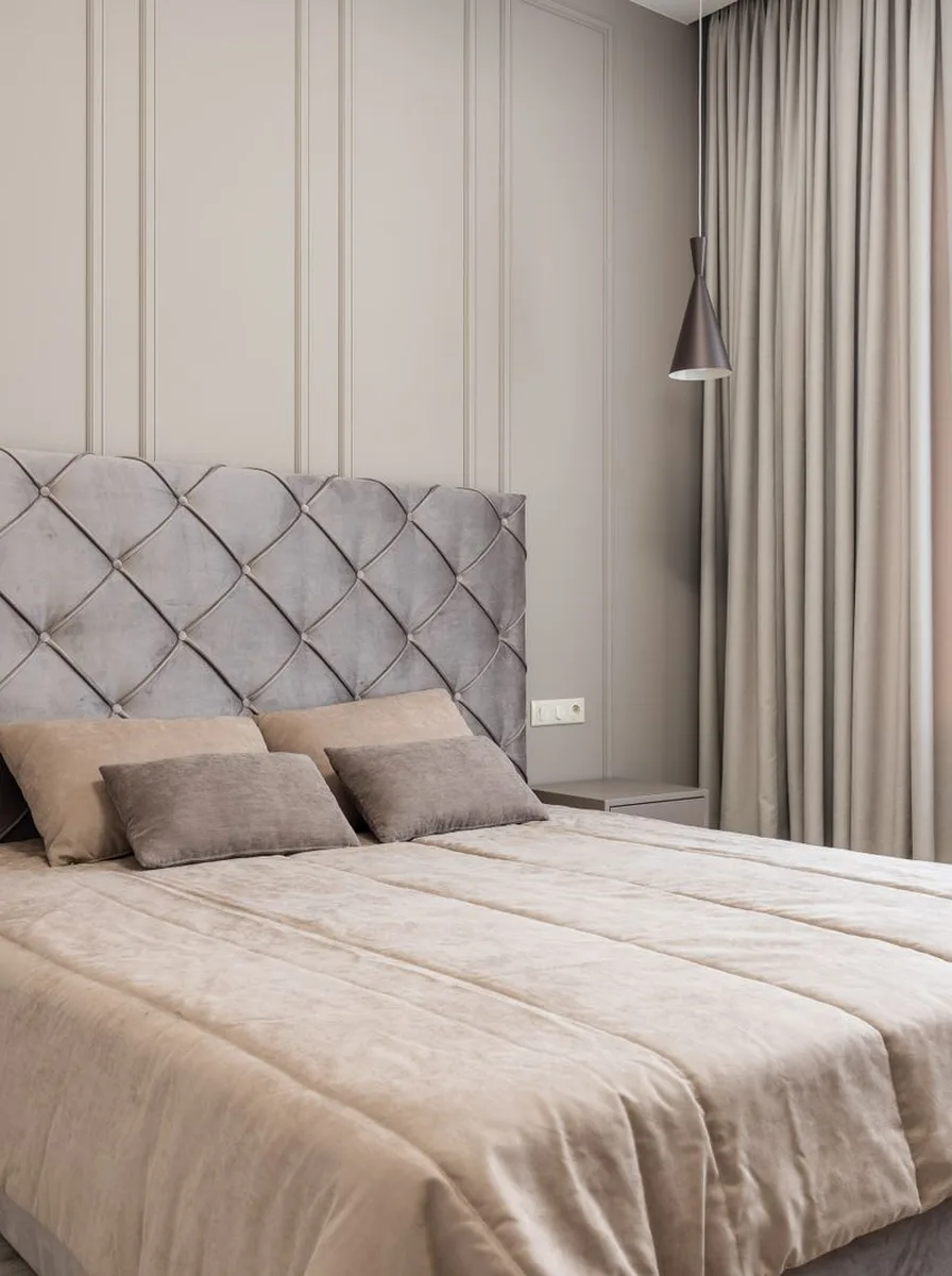 Beige tufted bed with curtains