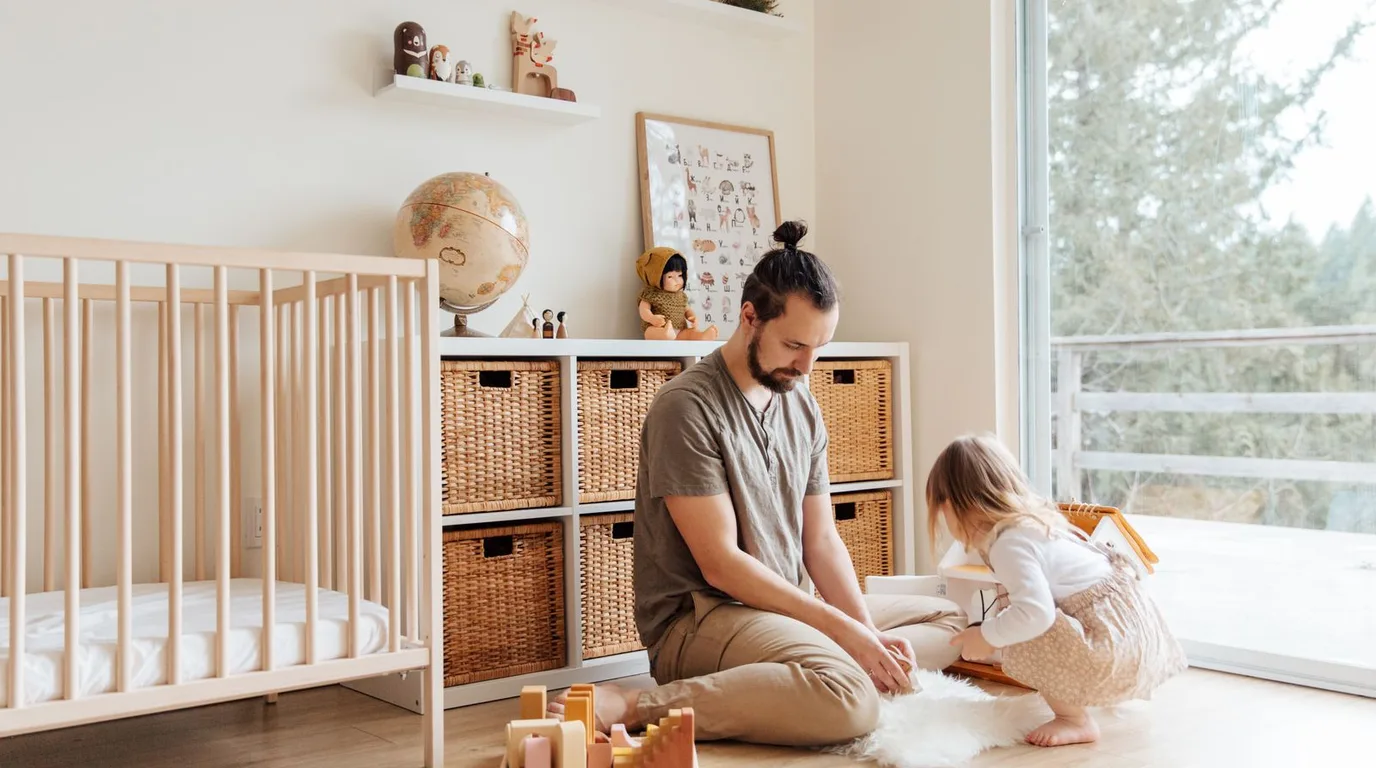 Gender neutral nursery with warm beige walls, natural wood crib, and cream textiles