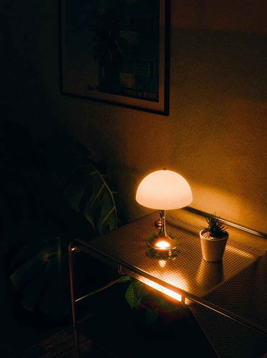 Small lamp glowing on a table in the dark