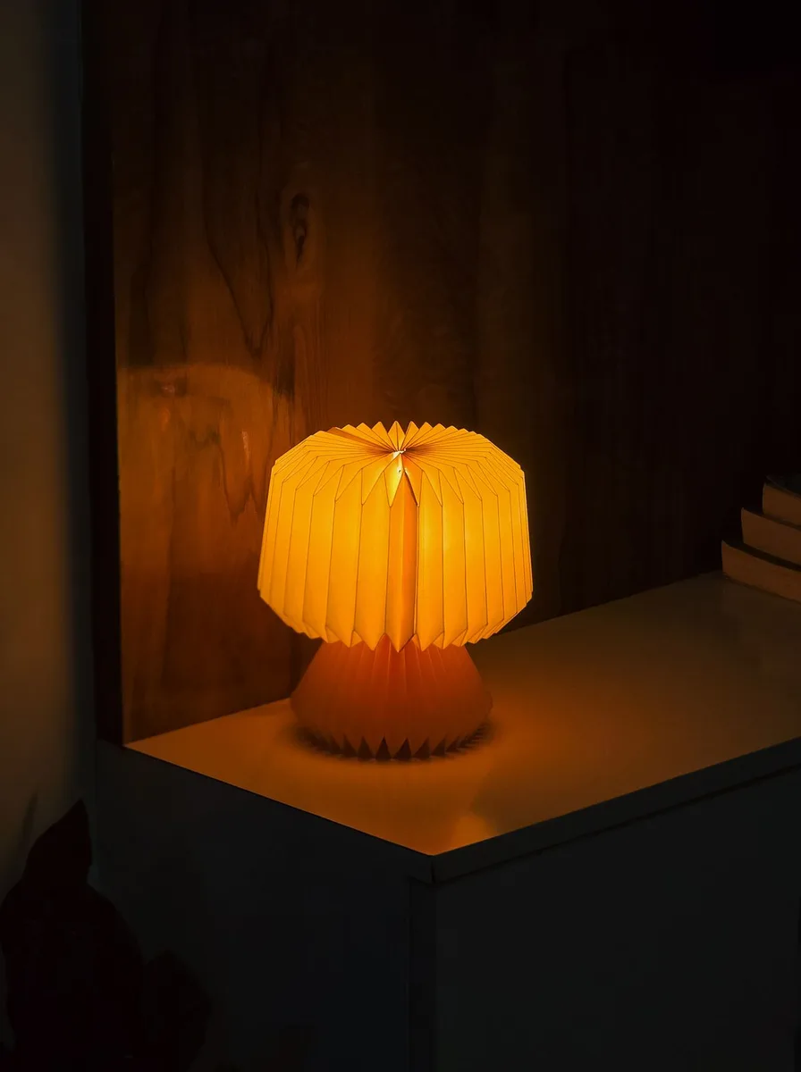 Orange paper lamp glowing in a dark room