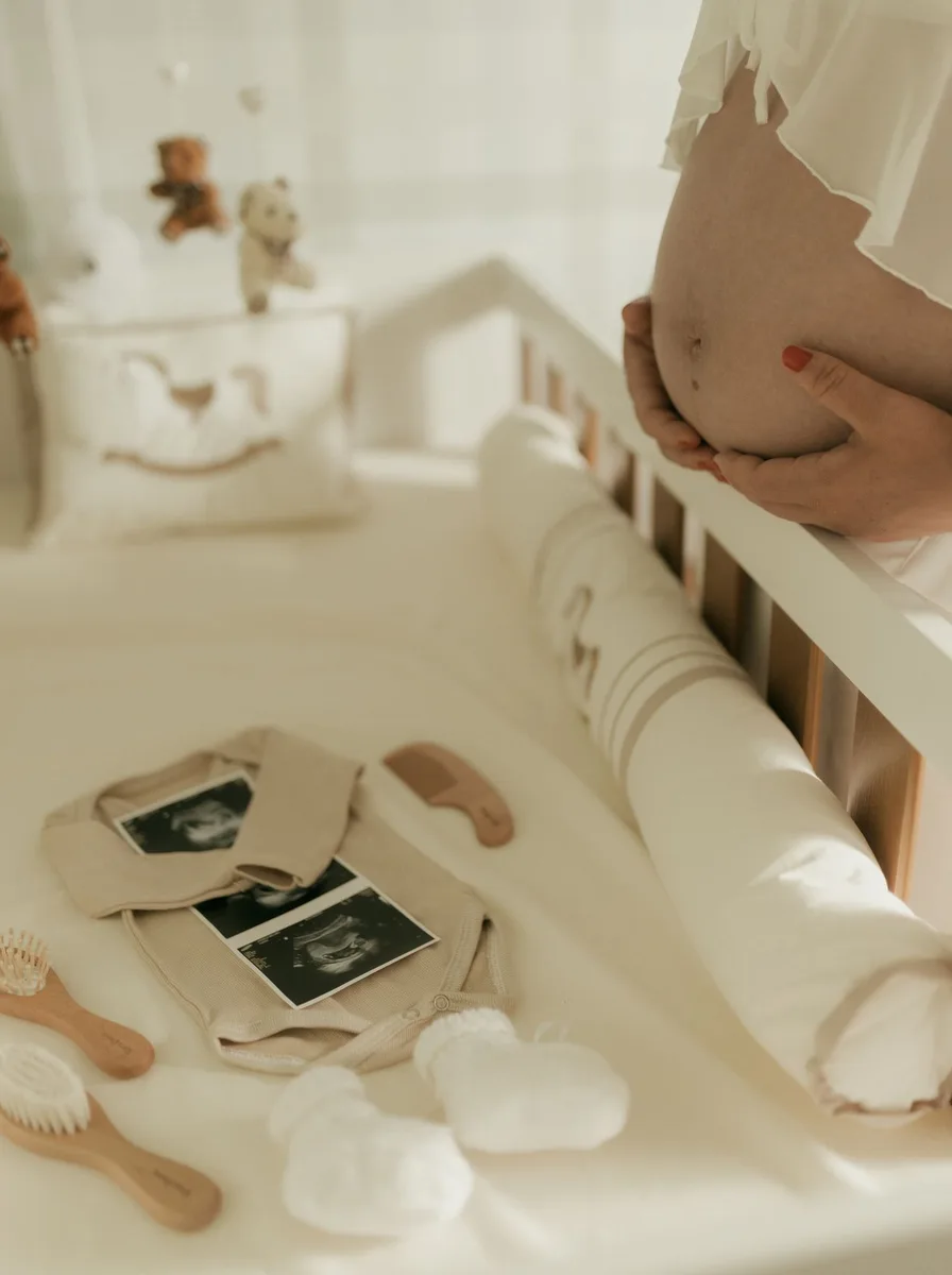 Pregnant woman beside a white crib