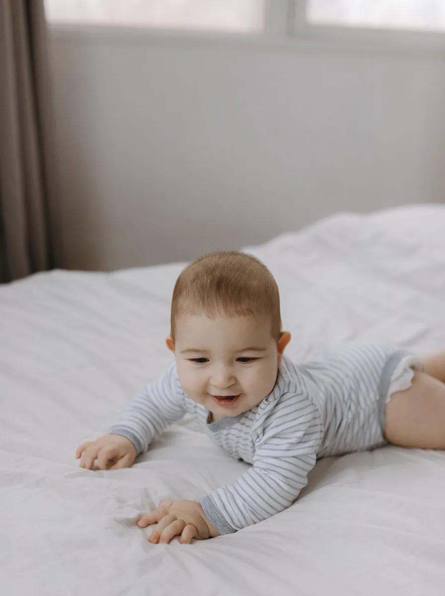 Baby crawling on a bed in a nursery