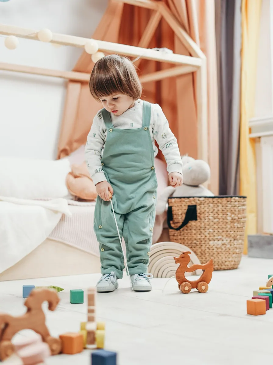 Toddler playing with wooden toys
