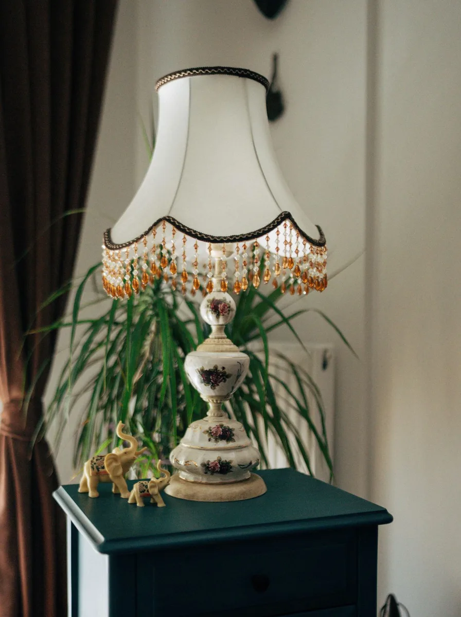 Ornate lamp on a teal side table