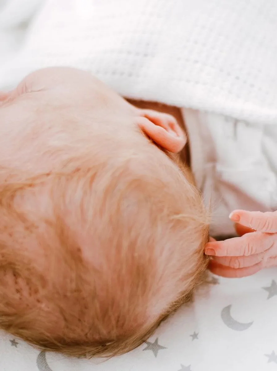 Close-up of a newborn baby in soft white