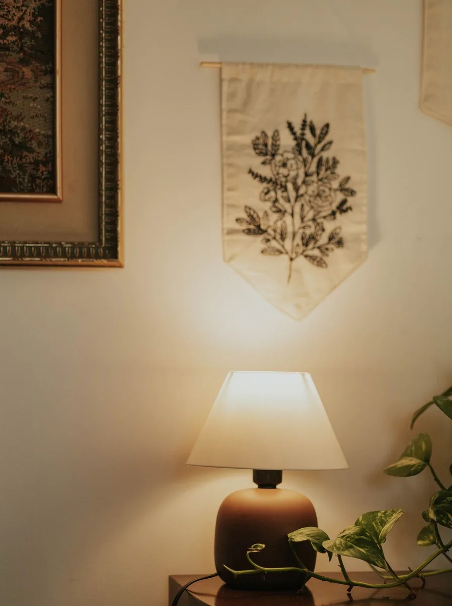 Woven wall hanging above a nursery lamp