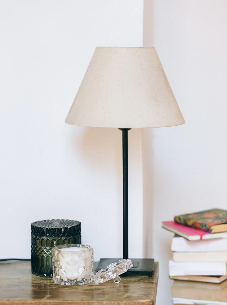 Warm table lamp glowing softly beside a nursery chair