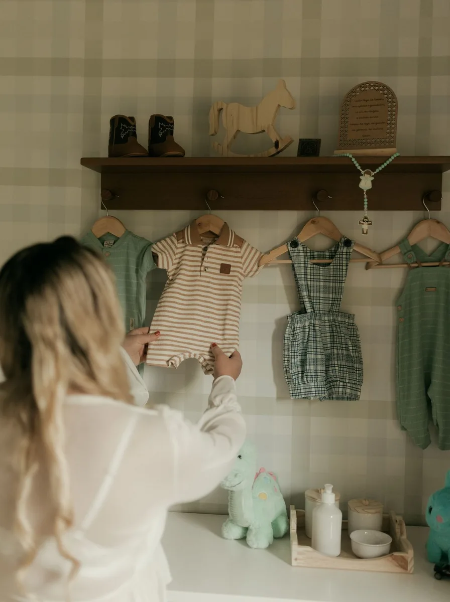 Woman hanging baby clothes in a closet