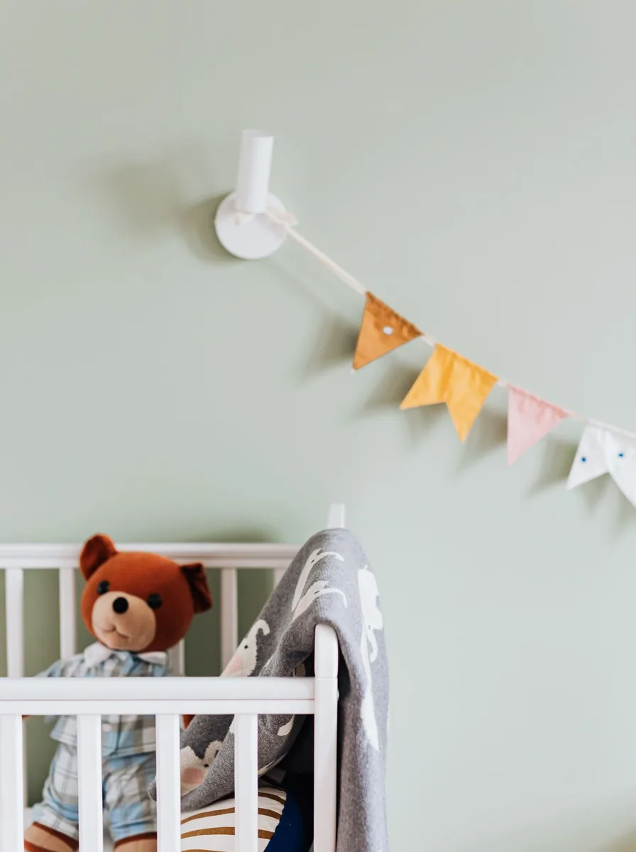 Teddy bear in a crib with bunting
