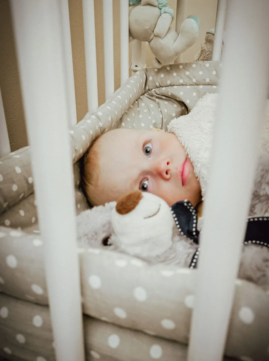 Baby lying in a white crib