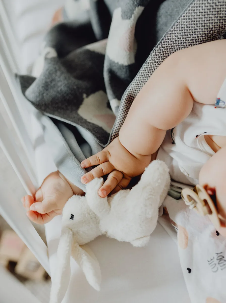 Baby holding a bunny plush