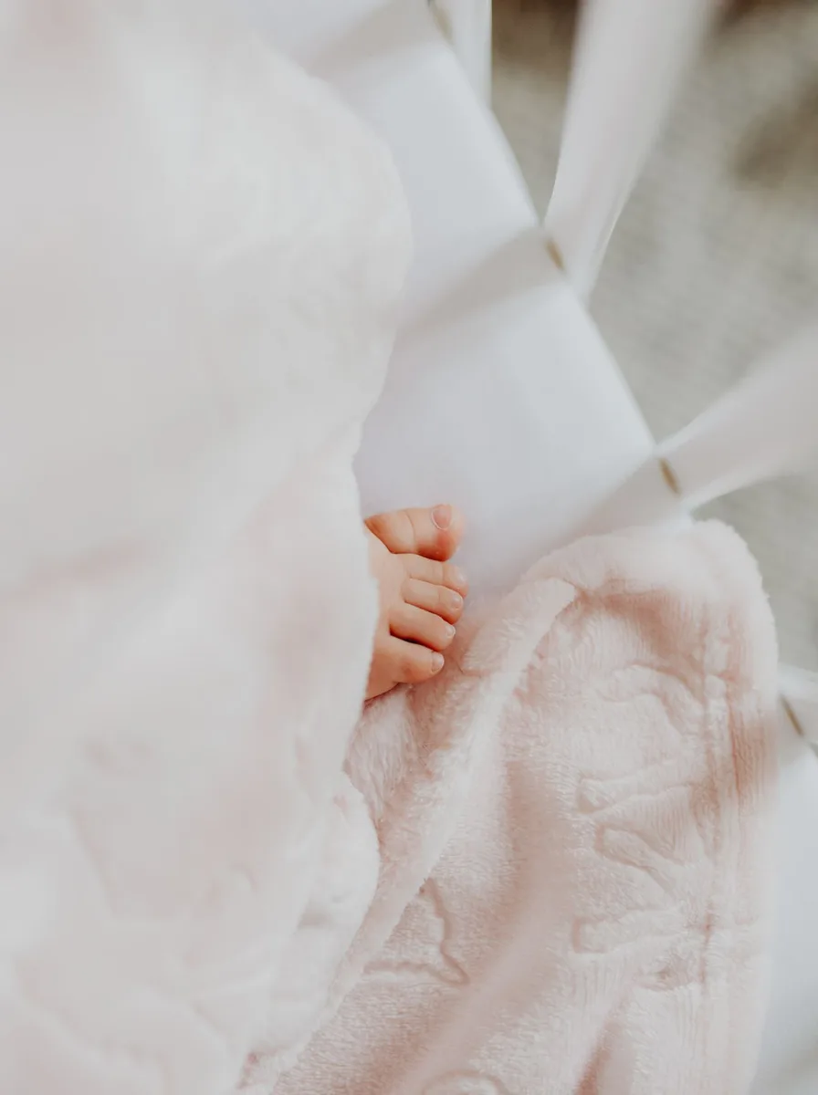 Baby feet on a pink blanket