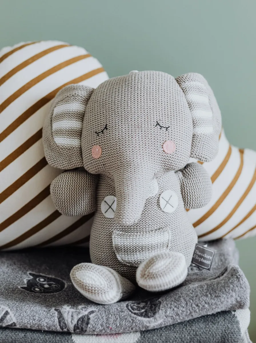 Grey elephant plush on folded blankets