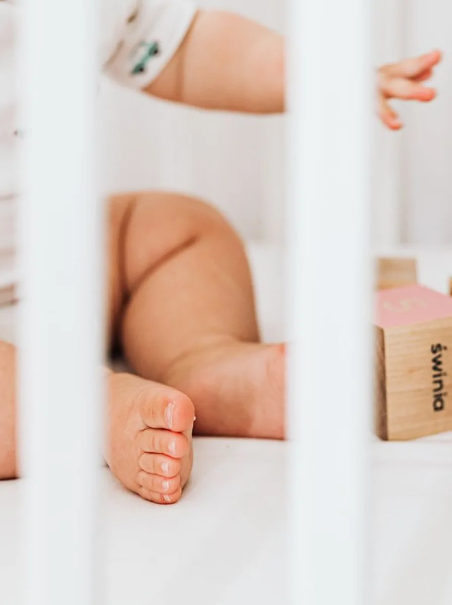 Baby feet beside wooden blocks