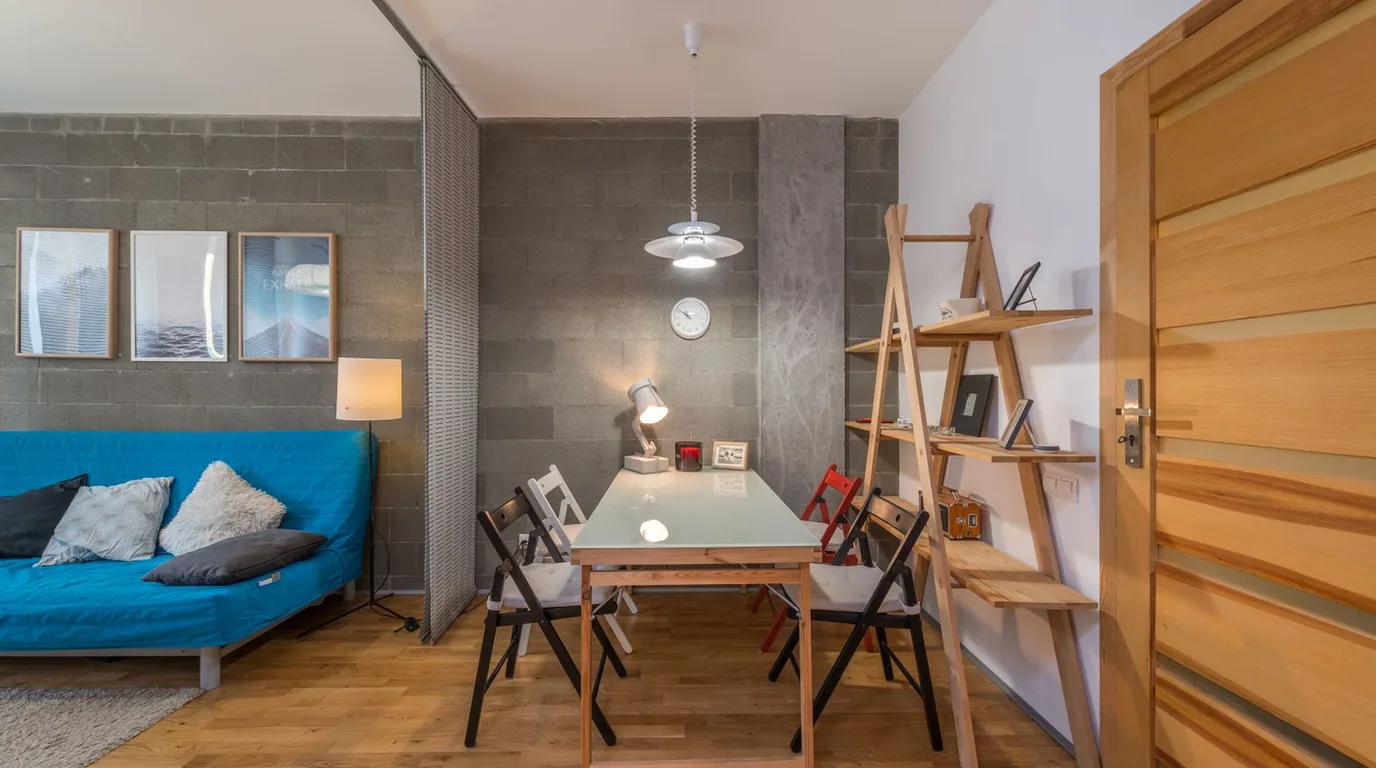 Bright tiny apartment with tall shelving using full wall height