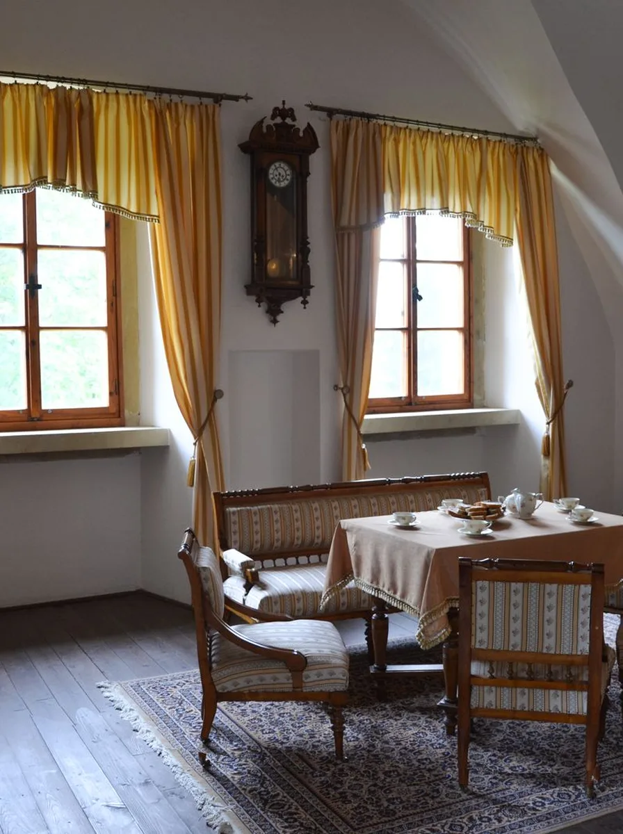Cozy dining nook with mustard curtains, a wall clock and small table