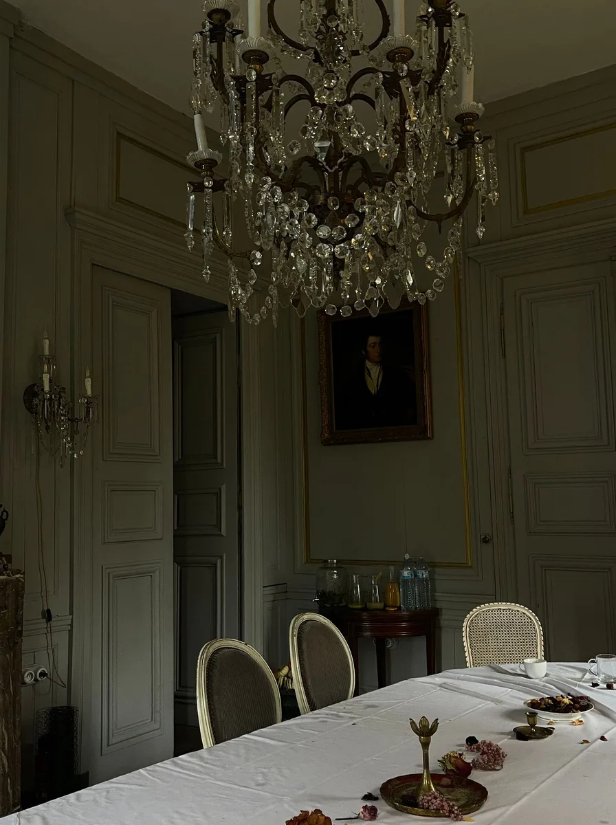 Rustic dining room with a crystal chandelier and green panelled walls