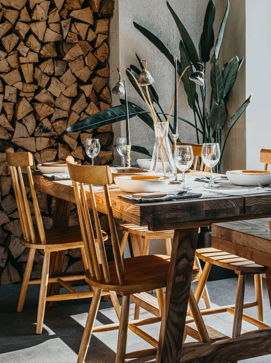 Rustic dining room with a stacked firewood wall and wooden dining table