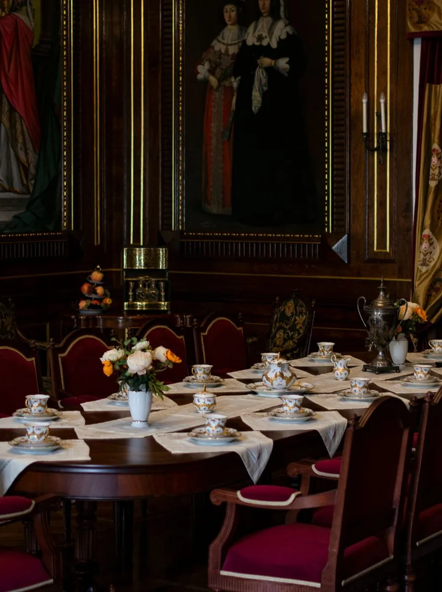 Rustic dining room with oxblood walls, white tablecloths and red chairs