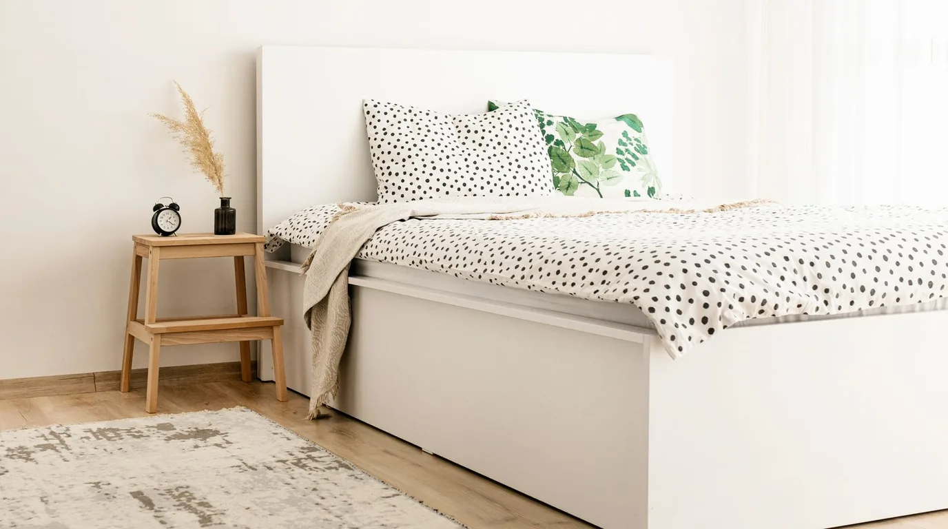 Small bright bedroom painted in light colours that make it look bigger