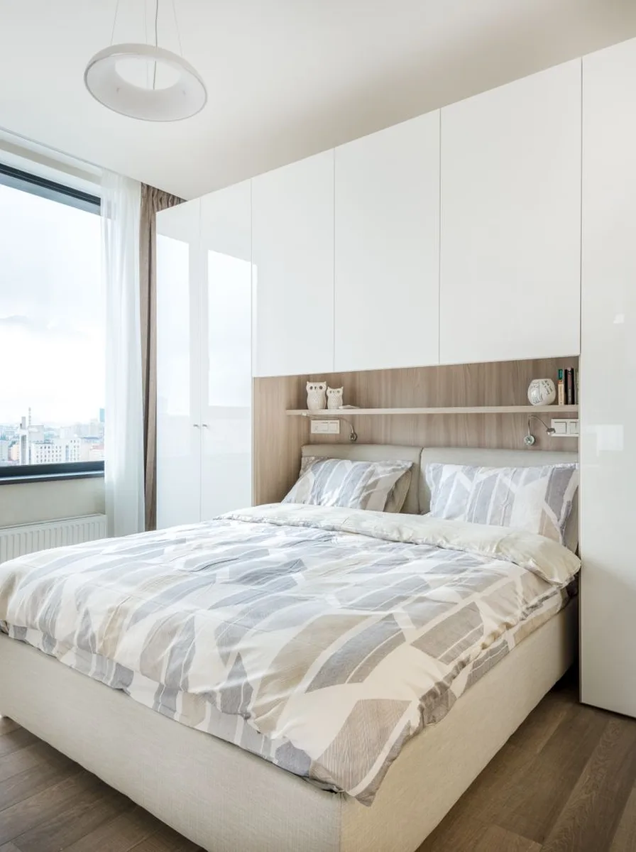 Small white bedroom with fitted wardrobe