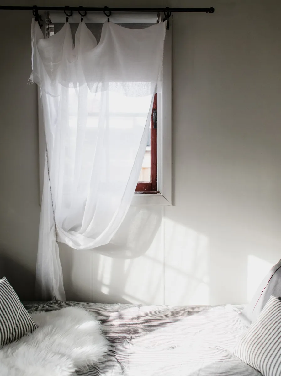 Hotel-style white layered bedding in tiny bedroom