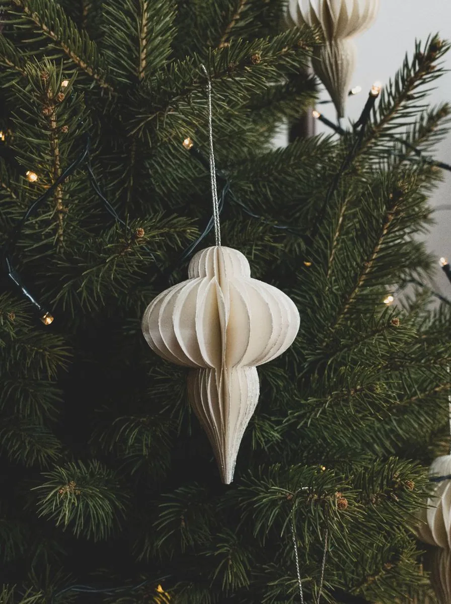 White paper ornament hanging on a Christmas tree
