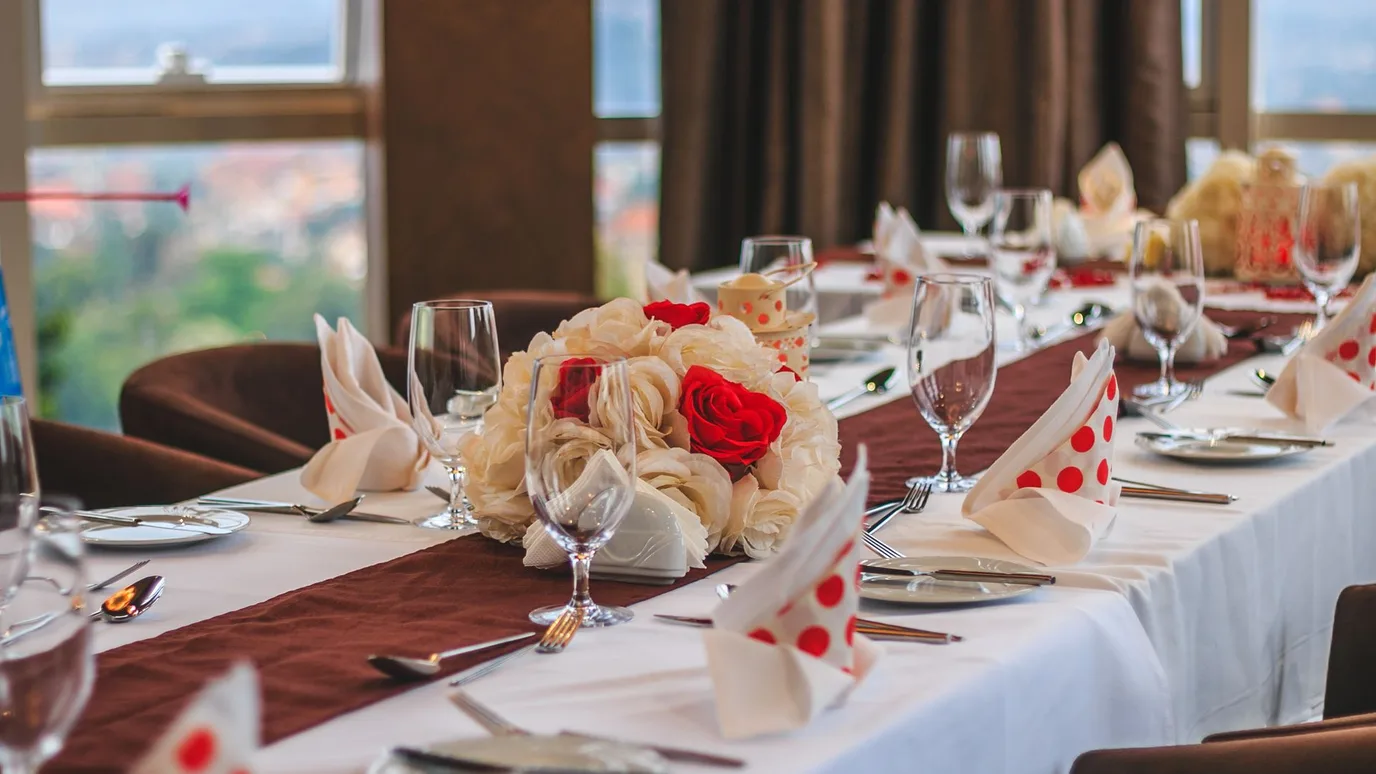 Dining table with an elegant centerpiece of tall vases, lanterns, and candles