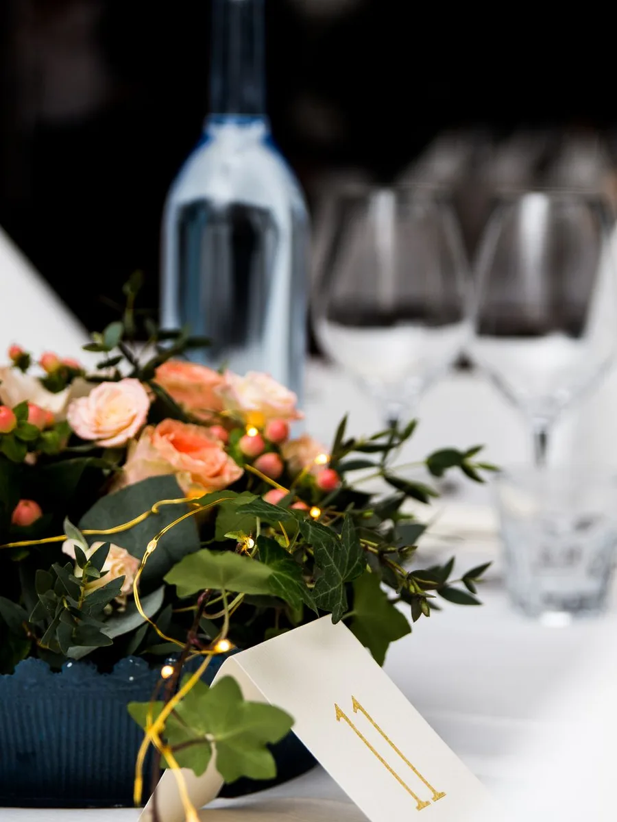 Glass vase of white hydrangeas on a dining table