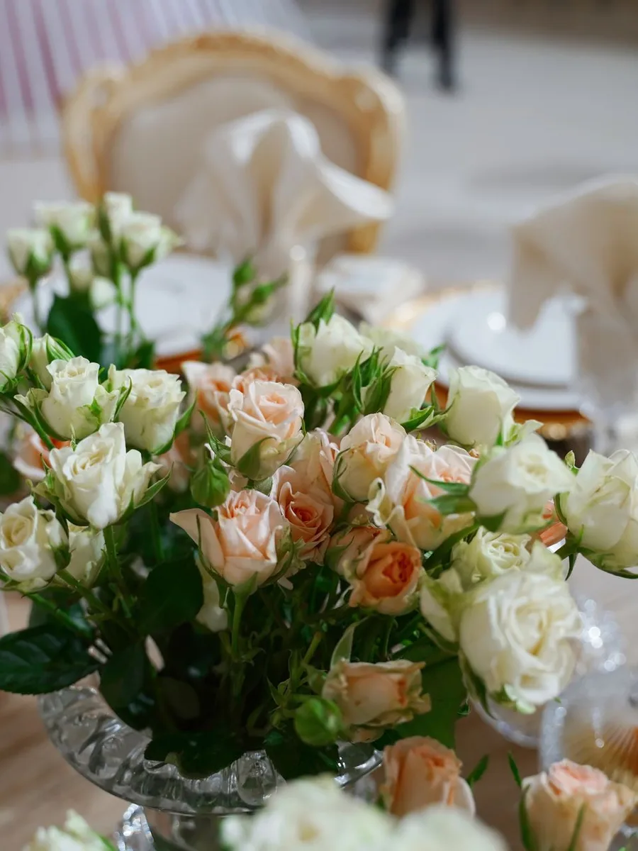 Vintage glass bottles with single flower stems on a dining table